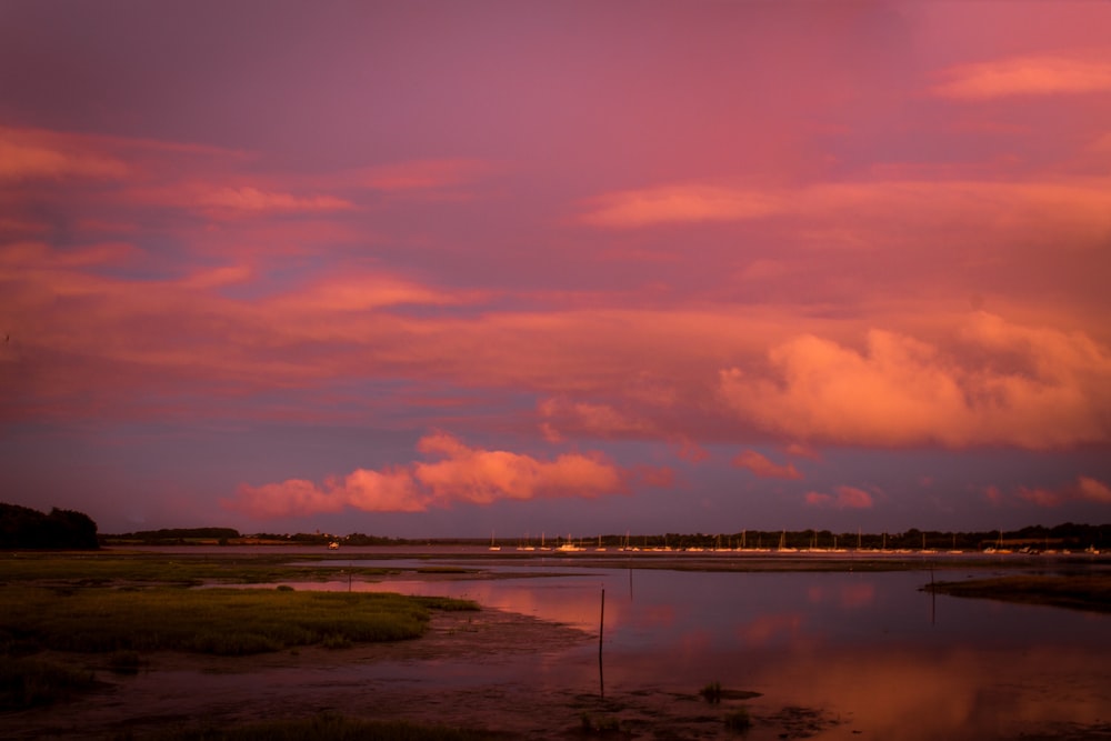 body of water under clouded sky during golden hour