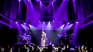 a woman standing on top of a stage in front of a crowd