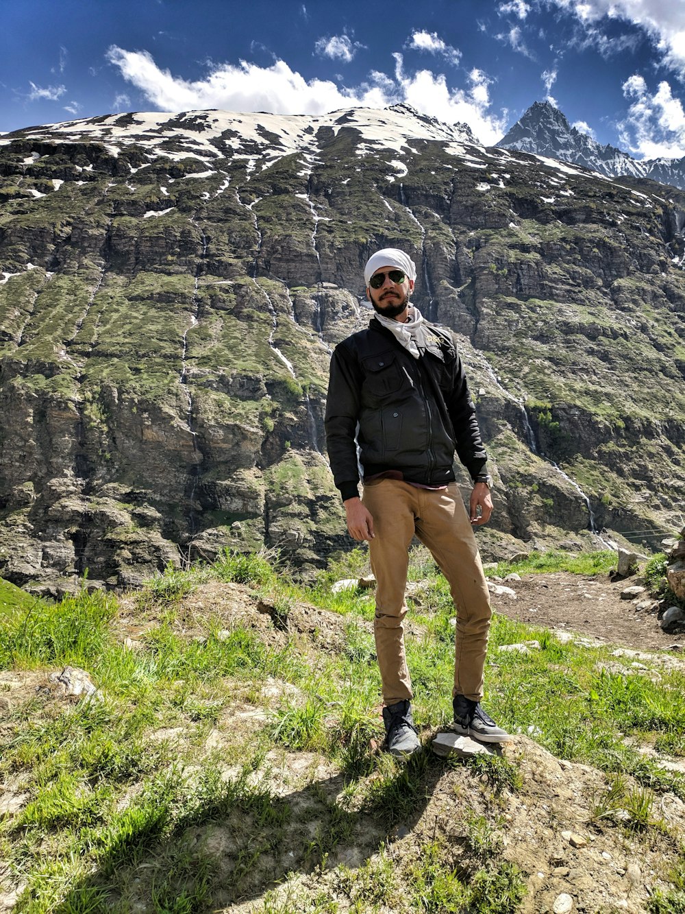 man standing with rock cliff at the back