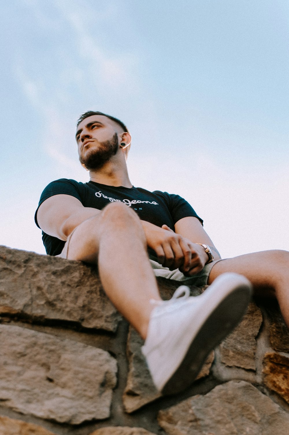 man in black shirt sitting on bricks