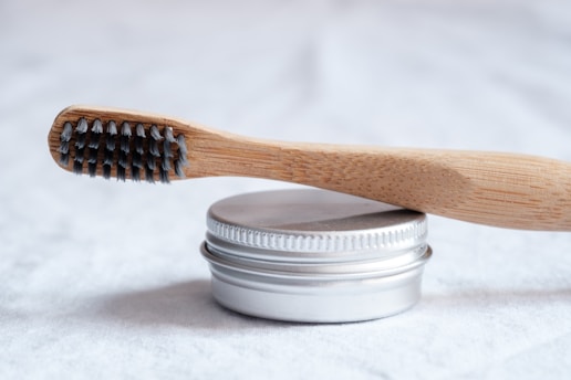 brown wooden toothbrush powder tin