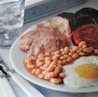 A plate English Breakfast showing beans, bacon and eggs 