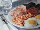 A plate English Breakfast showing beans, bacon and eggs 