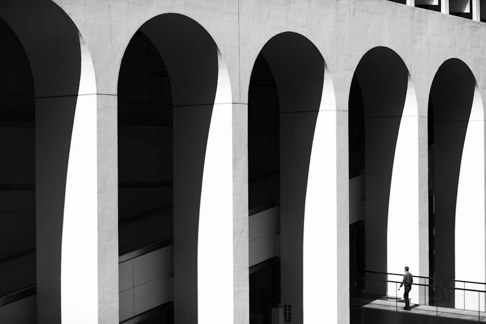 a black and white photo of a person on a balcony