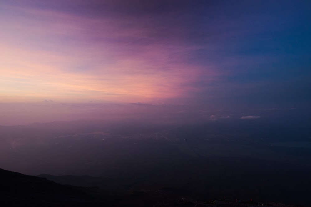 a purple and blue sky over a mountain range