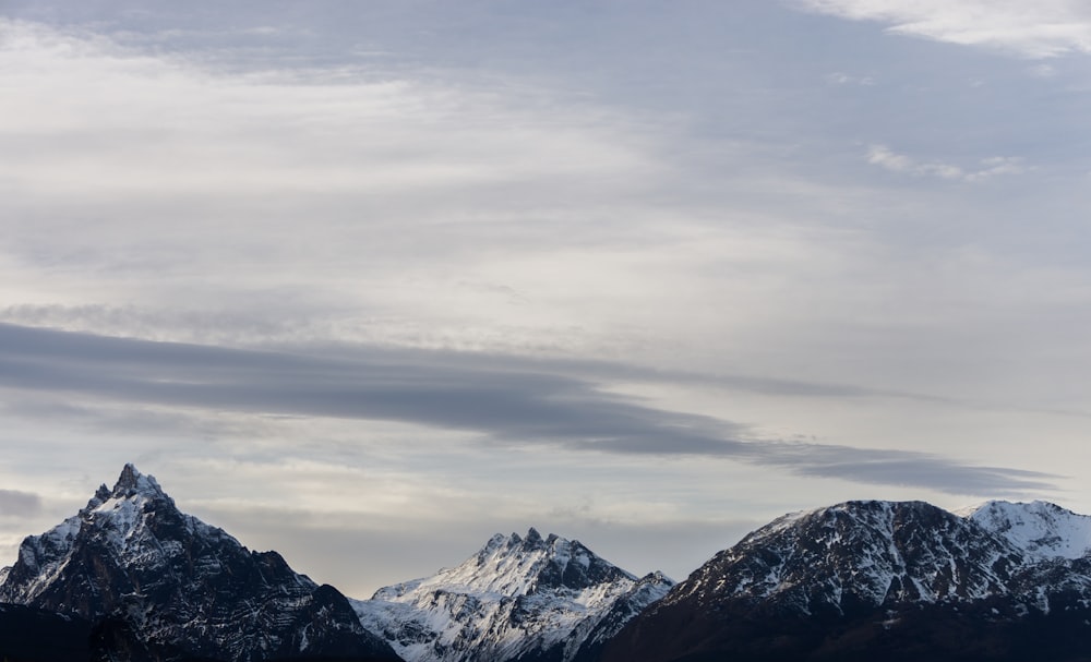 a mountain range with snow capped mountains in the background