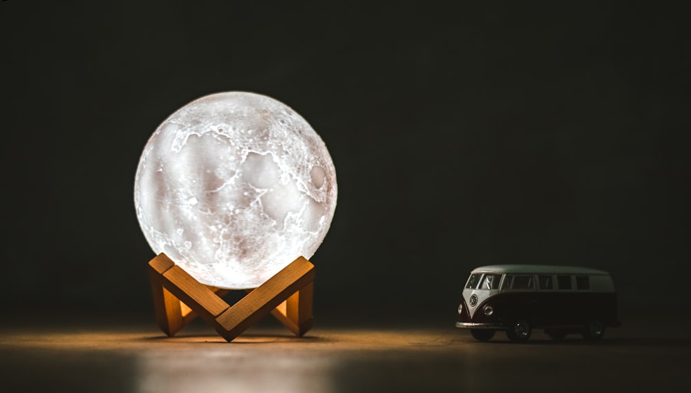 a van is parked next to a large moon lamp