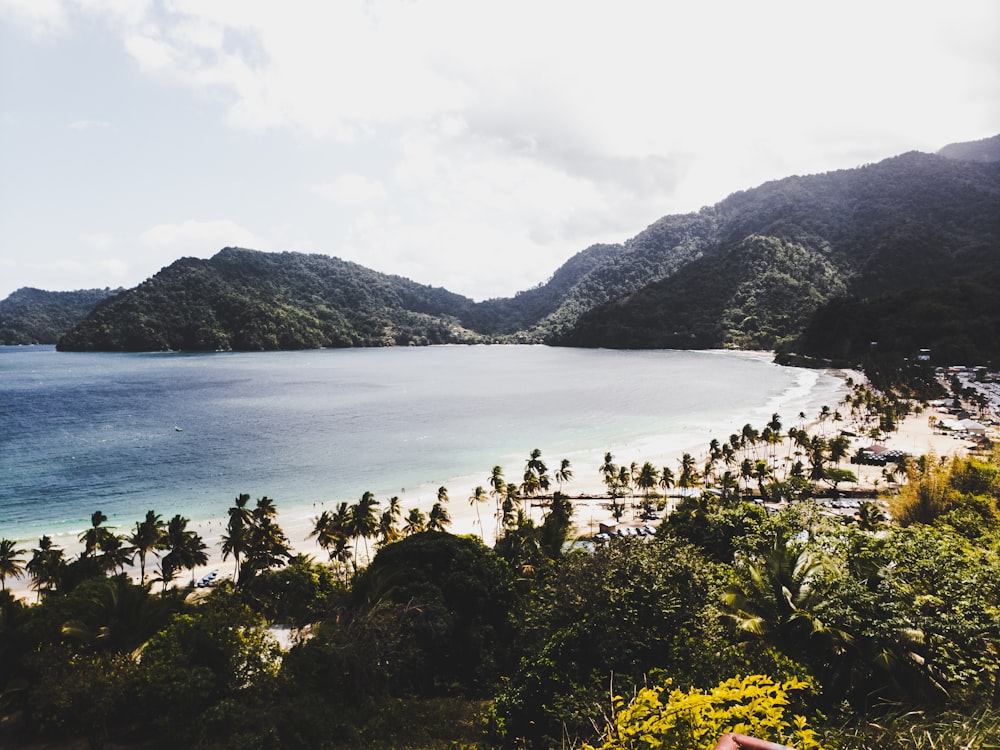 calm body of water near mountain at daytime