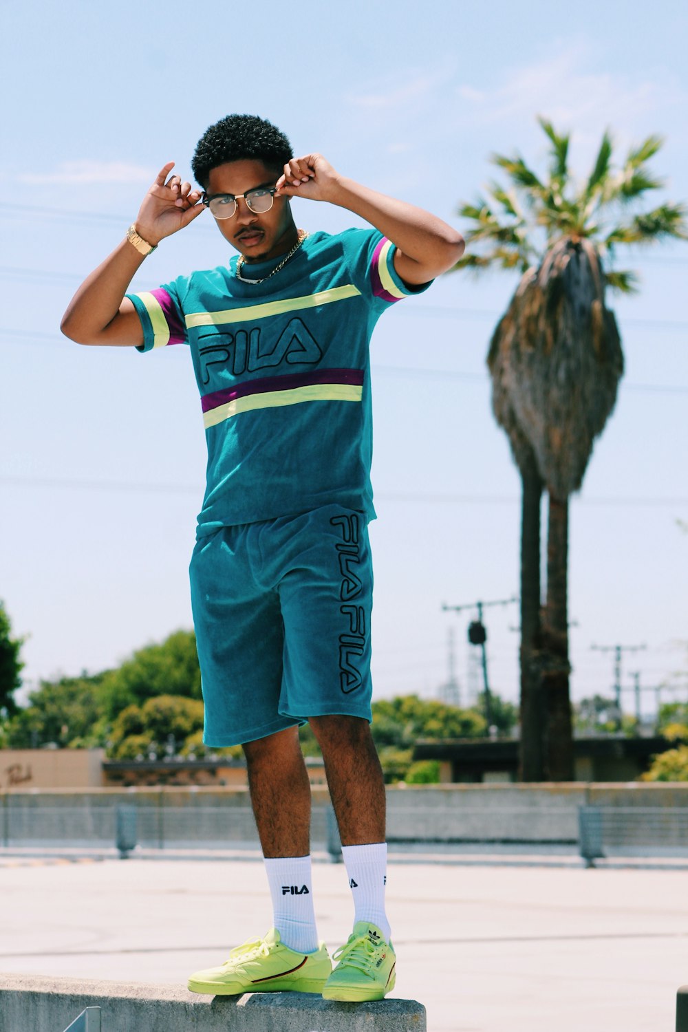 Man in teal Fila shirt and shorts standing on concrete ground photo – Free  Apparel Image on Unsplash