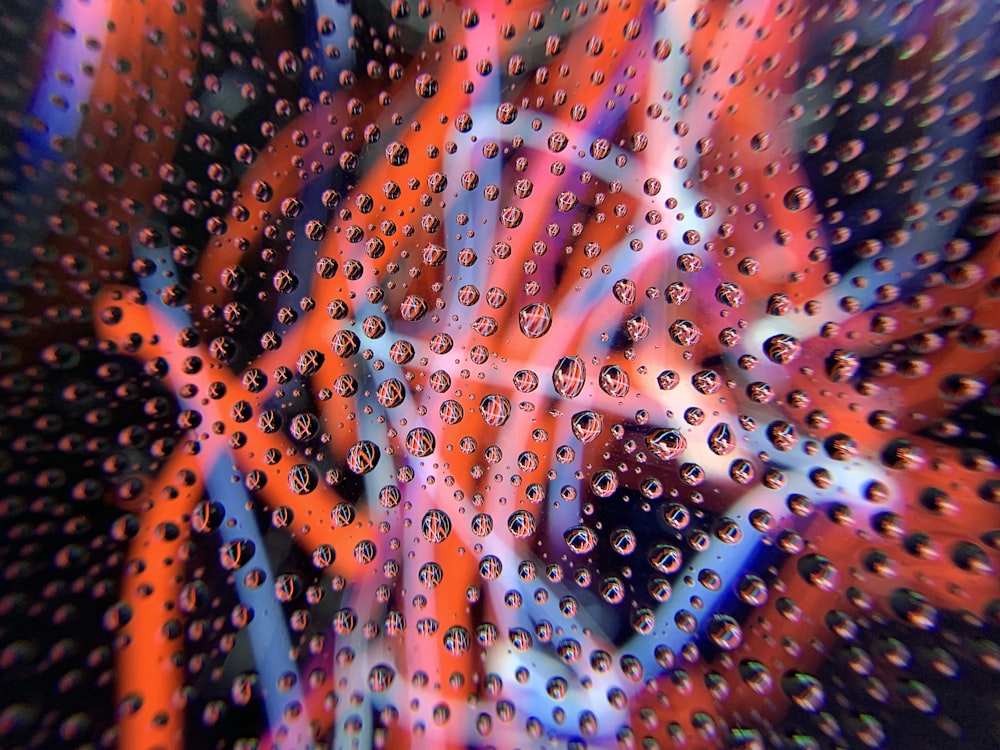 water droplets on glass panel with red and blue light waves