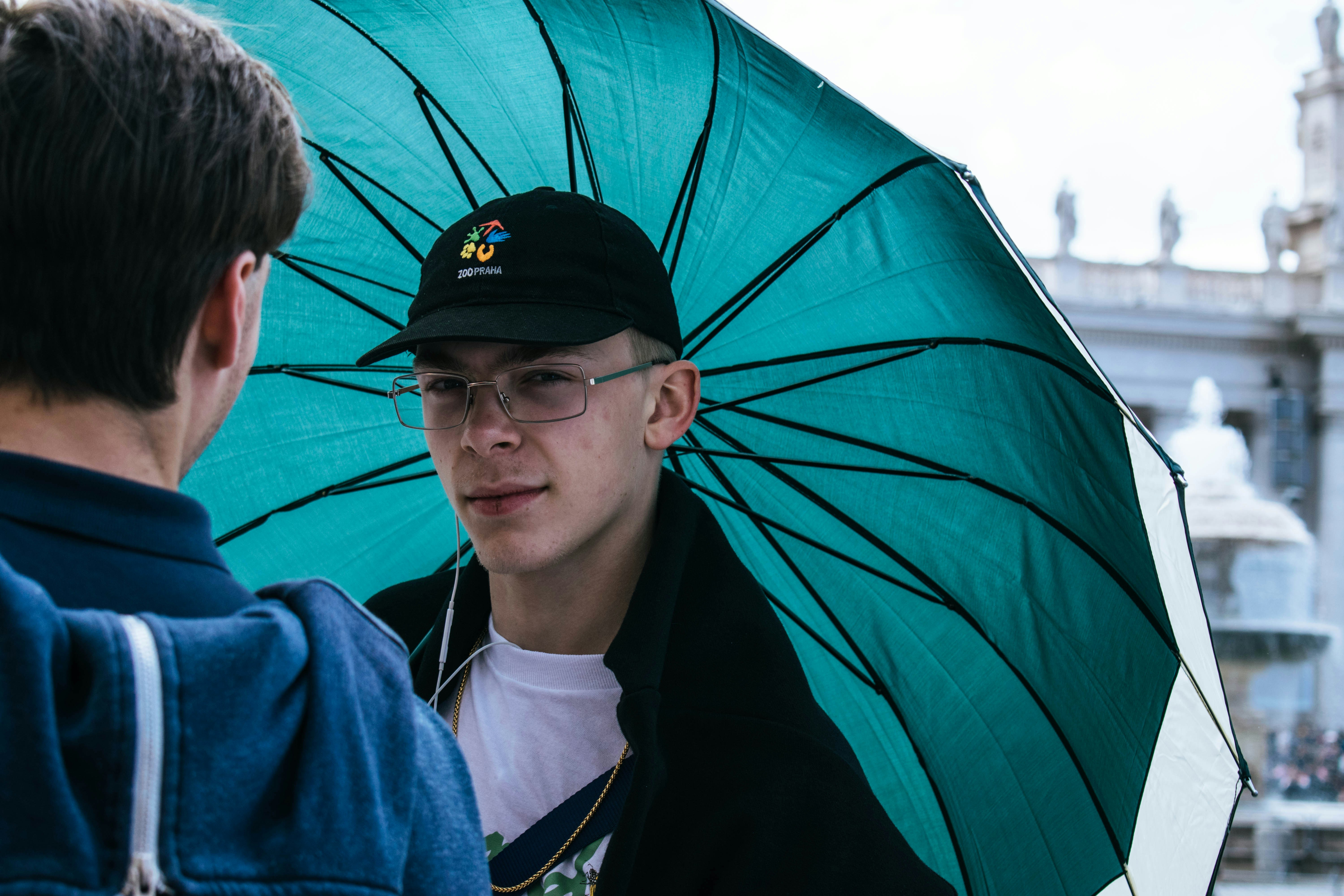 hombre con paraguas azul y negro