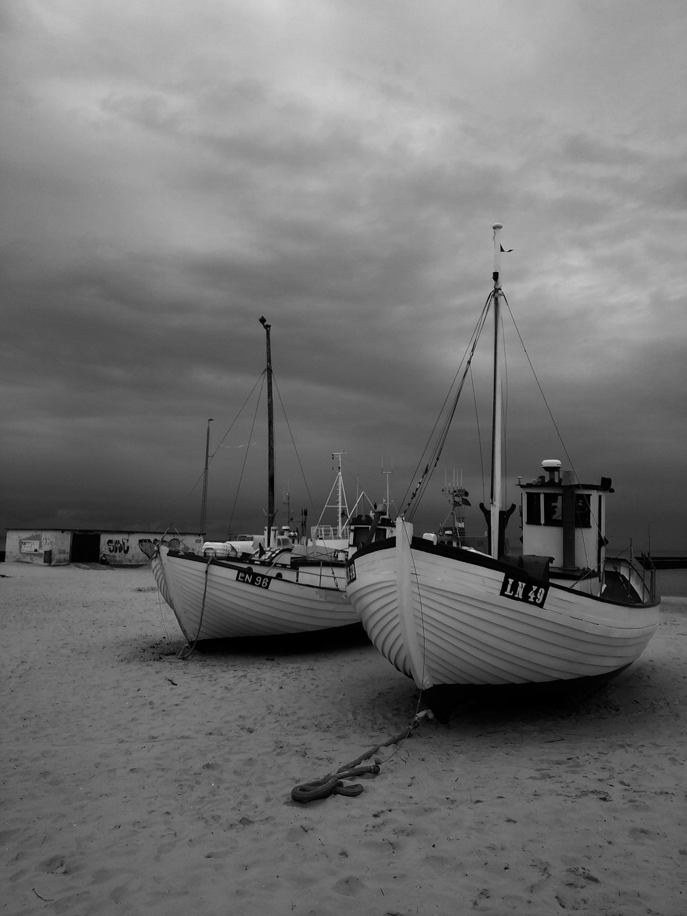 grayscale photography of boats on field