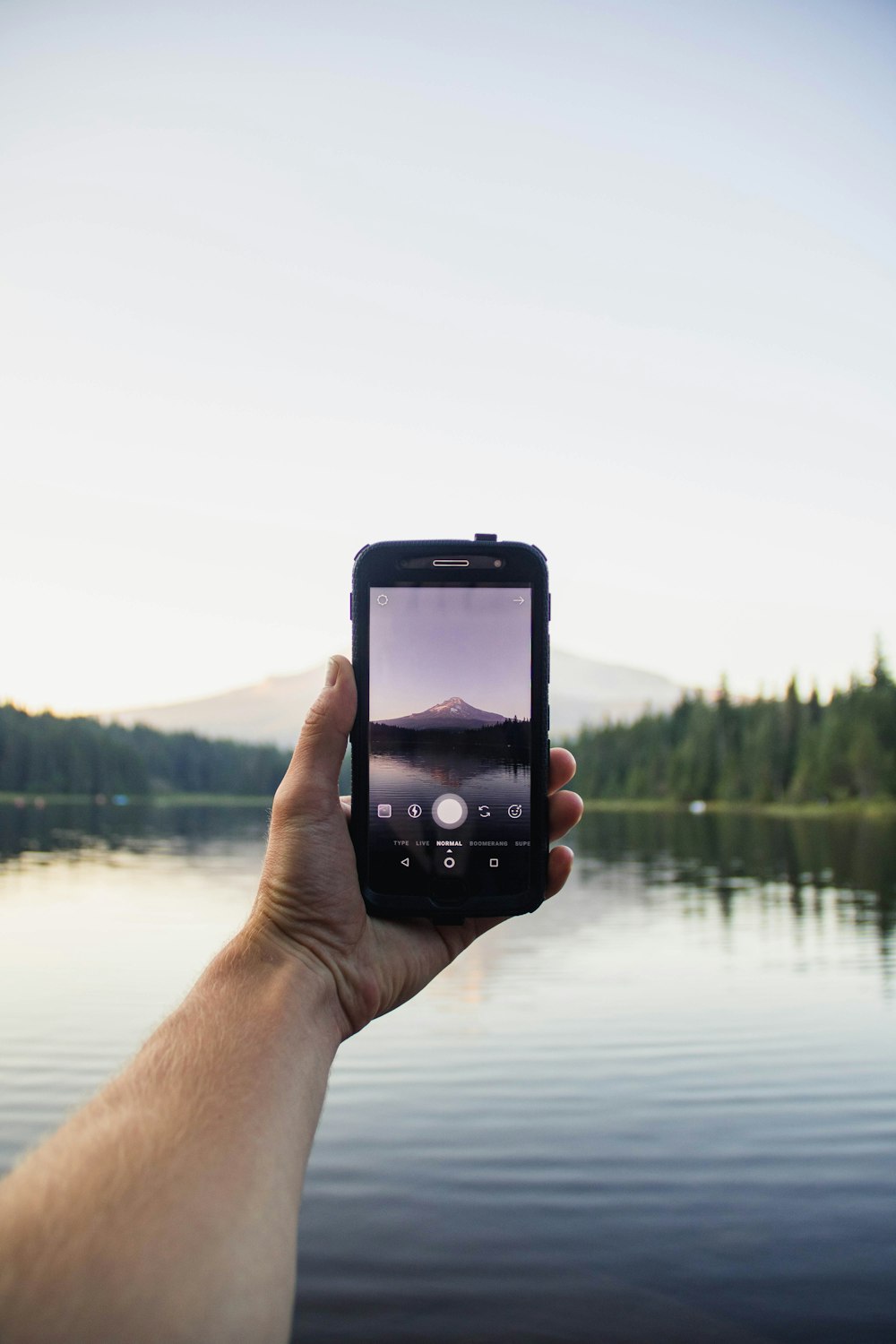 Persona sosteniendo un teléfono móvil negro