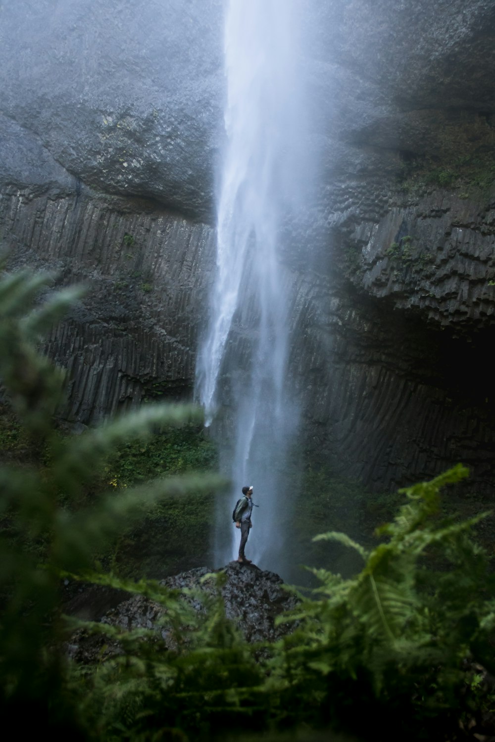 person standing near waterfalls