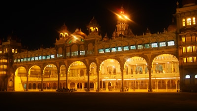 The majestic Mysore Palace illuminated at dusk, showcasing its intricate architecture.