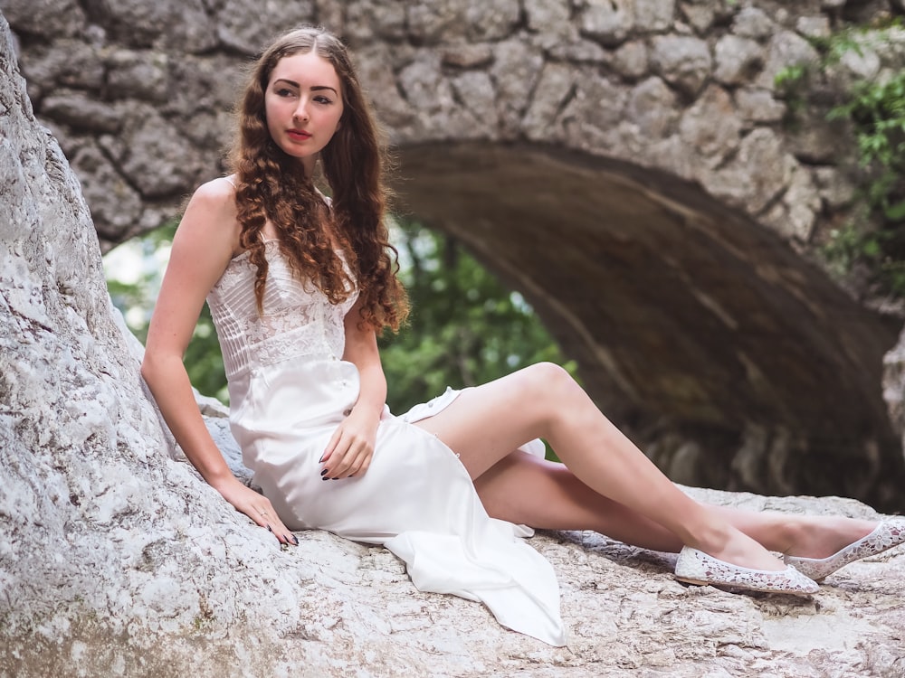 woman sitting on big rock facing her right side