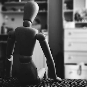 wood manikin on bed