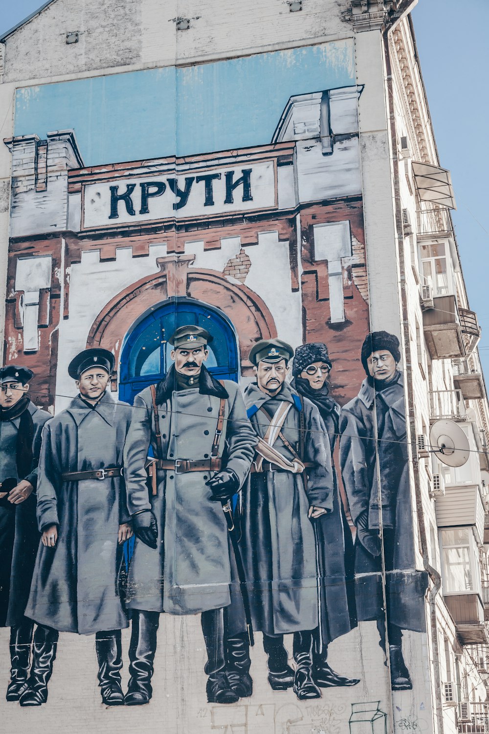 a mural of a group of men standing in front of a building