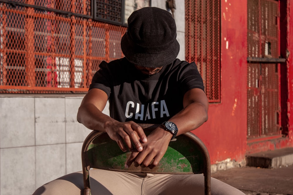 man in black and white crew-neck t-shirt sitting on chair