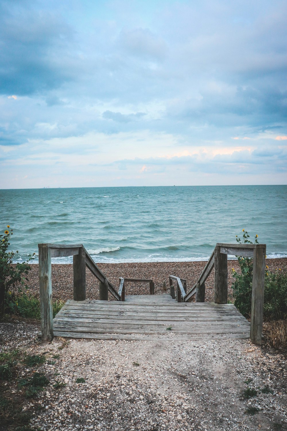 grey wooden stairs in front of beach