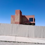 Small commercial building with new blue and white fencing along the perimeter.