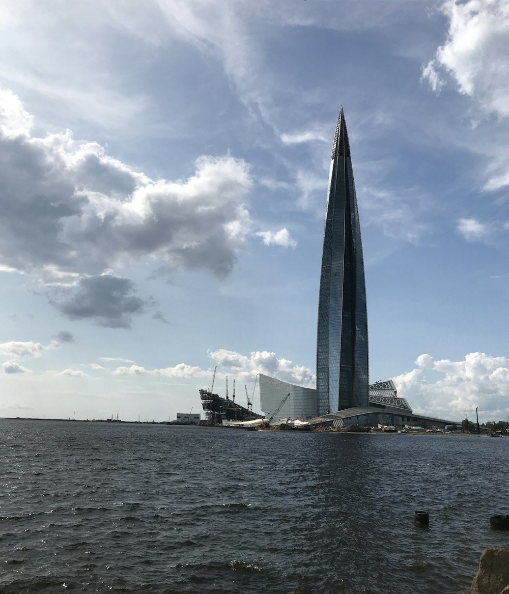 Schwarz-grauer Turm neben Gewässer bei Tag