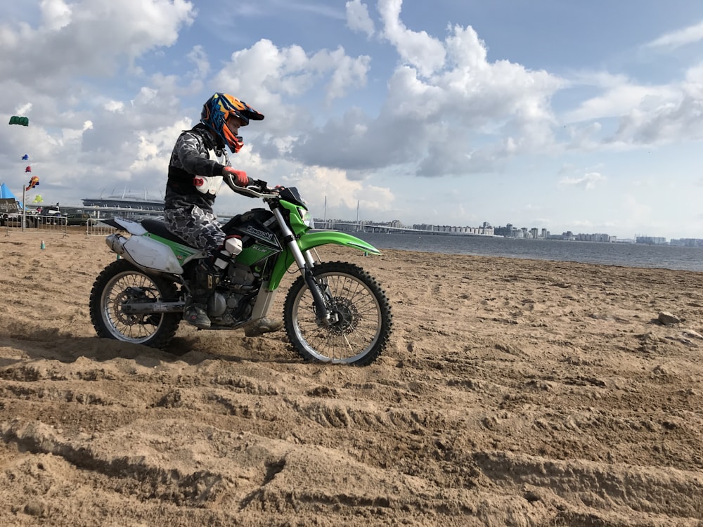 昼間、砂の近くでモトクロスダートバイクに乗っている男