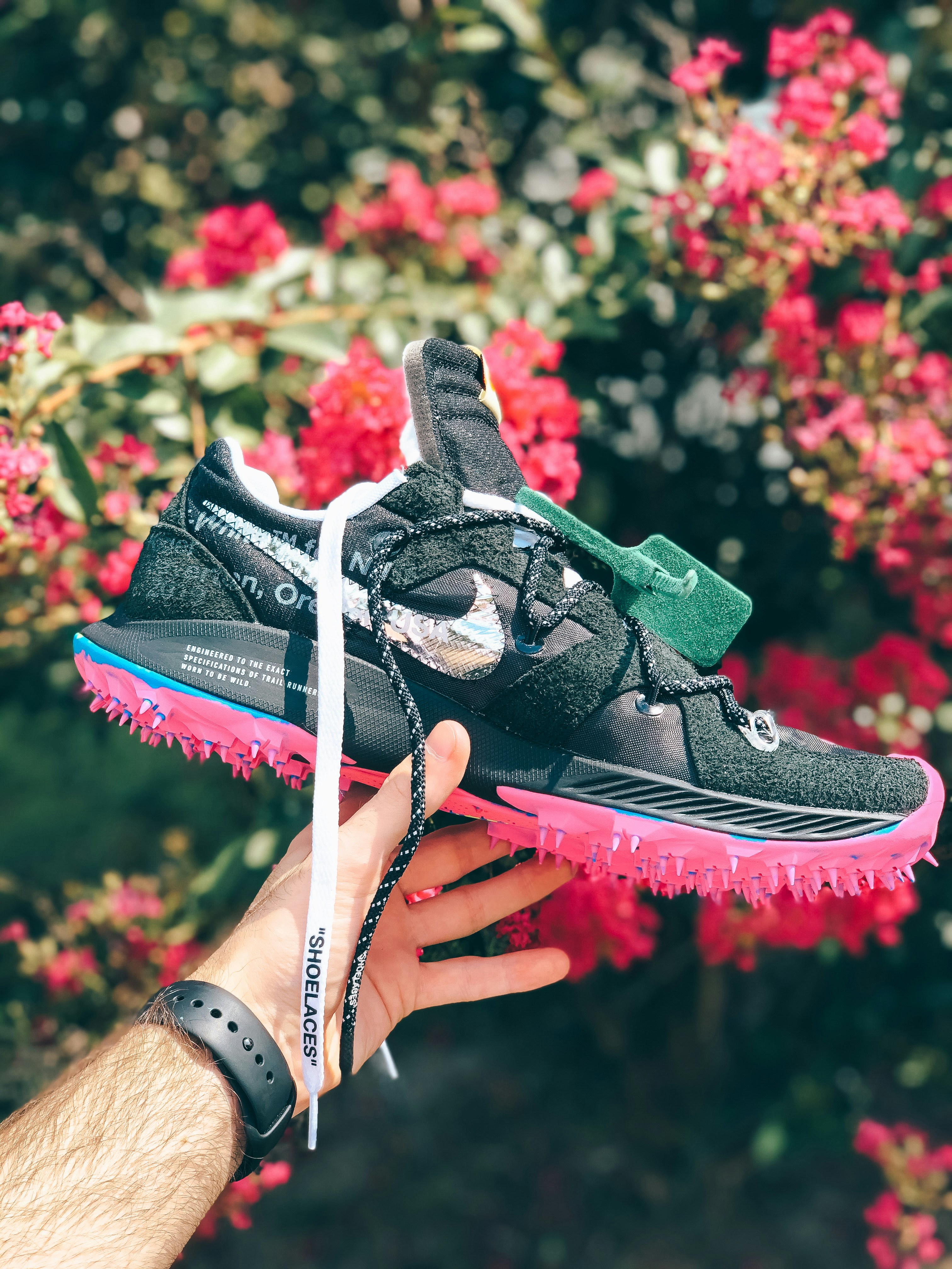 unpaired black and pink Nike running shoe