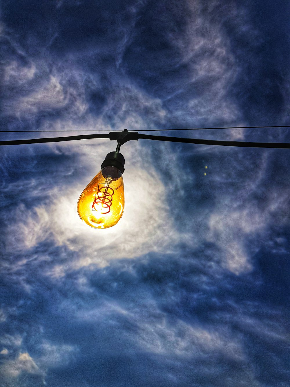 yellow light bulb under blue sky