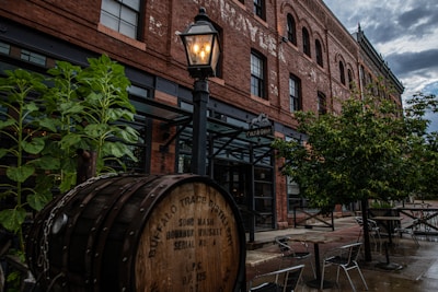Guests savoring whiskey samples under string lights at a lively outdoor tasting area.