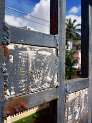 A local team member fixing a beach house gate under clear skies.