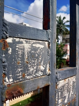 A local team member fixing a beach house gate under clear skies.