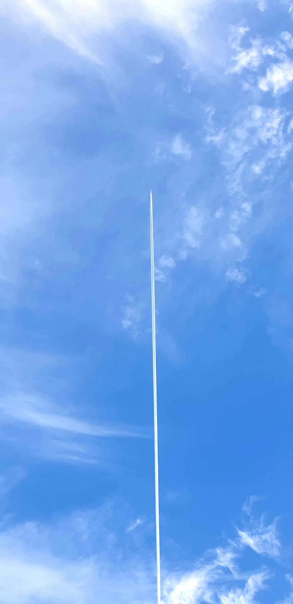 a plane flying high in the blue sky