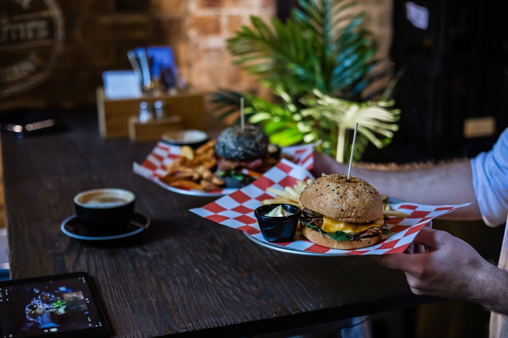 person holding cheese burger on plate