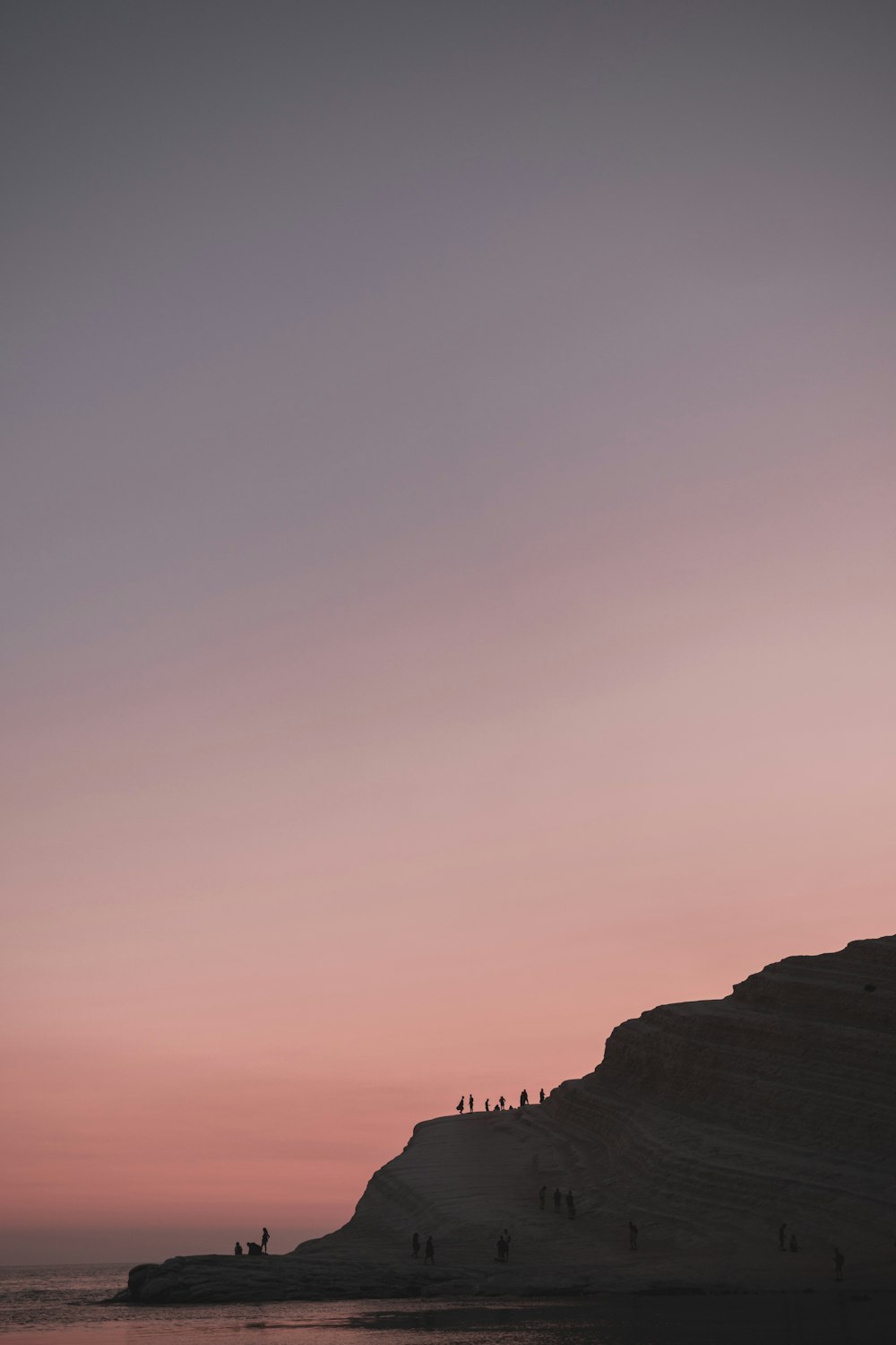 Menschen auf grauen Hügeln während des Sonnenuntergangs