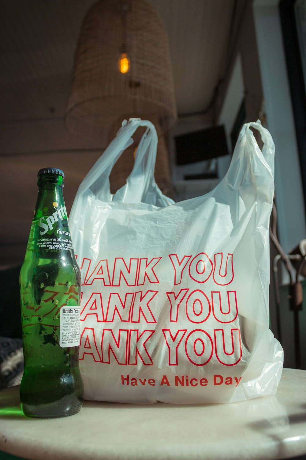 white and red plastic bag beside of Sprite soda bottle