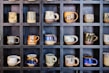 Stylish ceramic mugs displayed on a shelf.