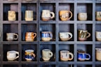 Stylish ceramic mugs displayed on a shelf.