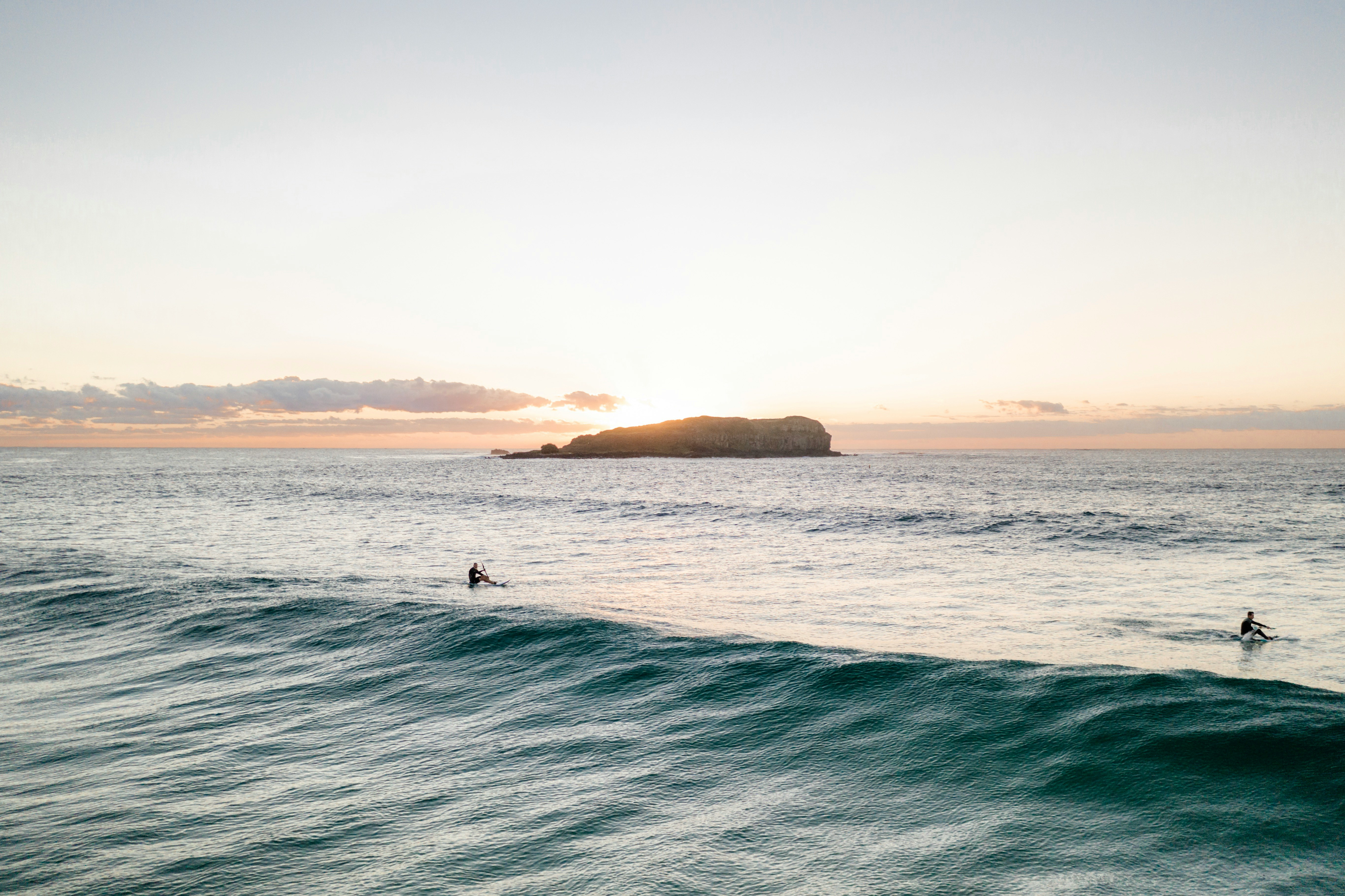 photo of black islet and ocean