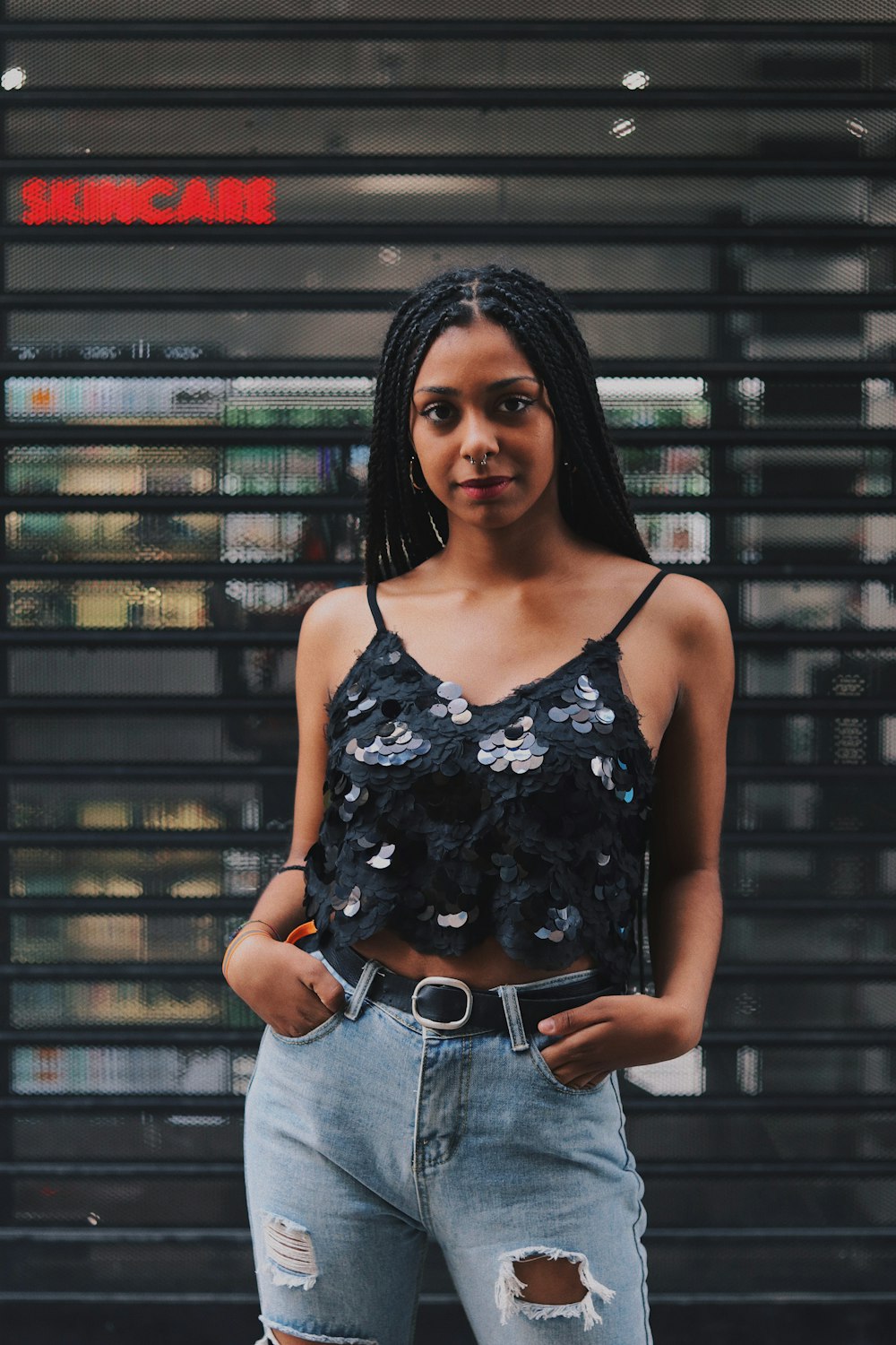 women wearing a black camisole and a distressed blue jeans close-up photography