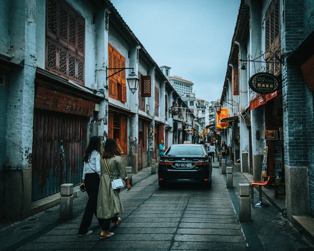 two women walking front of car