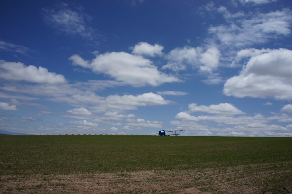 green plain field under cloudy sky