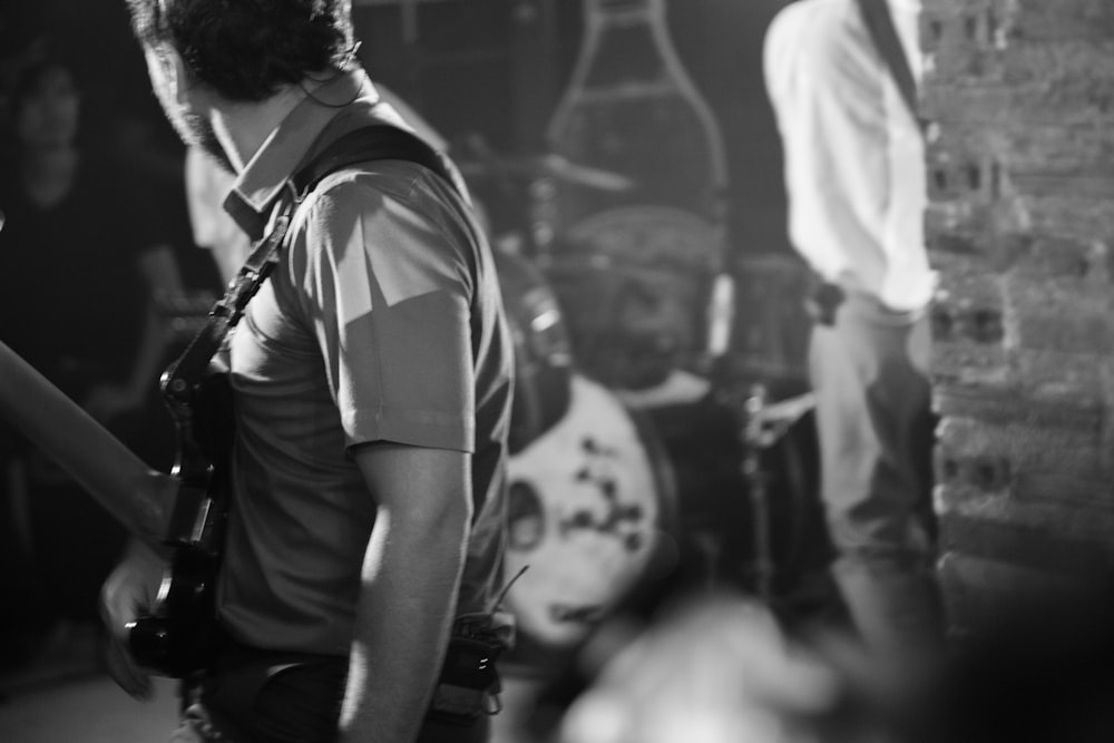 man wearing polo shirt carrying guitar