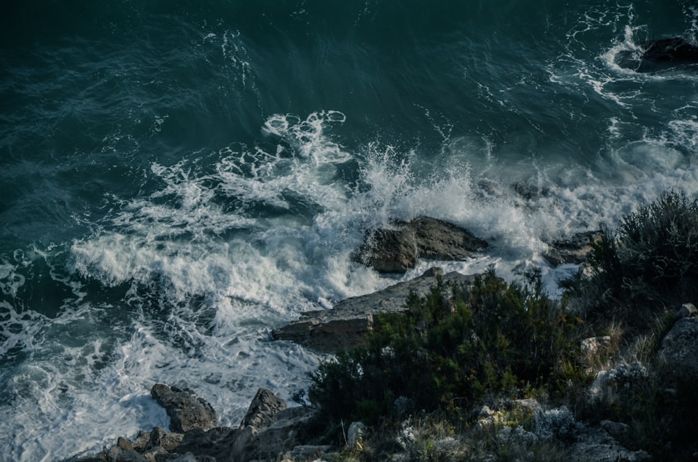 top view of sea waves crashing rocks