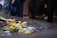 A variety of colorful plastic toys float in a clear rectangular water basin. The toys include ball-shaped objects and animals in bright colors such as yellow, blue, pink, and green. There is a partial view of a person standing nearby, wearing a blue striped garment.