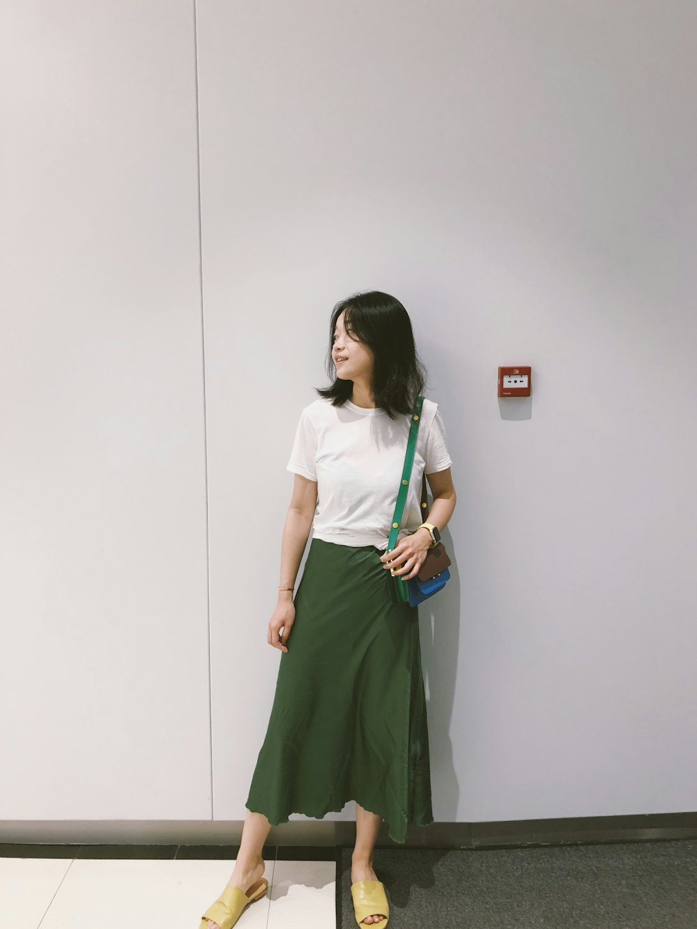 woman looking at her right standing against the wall