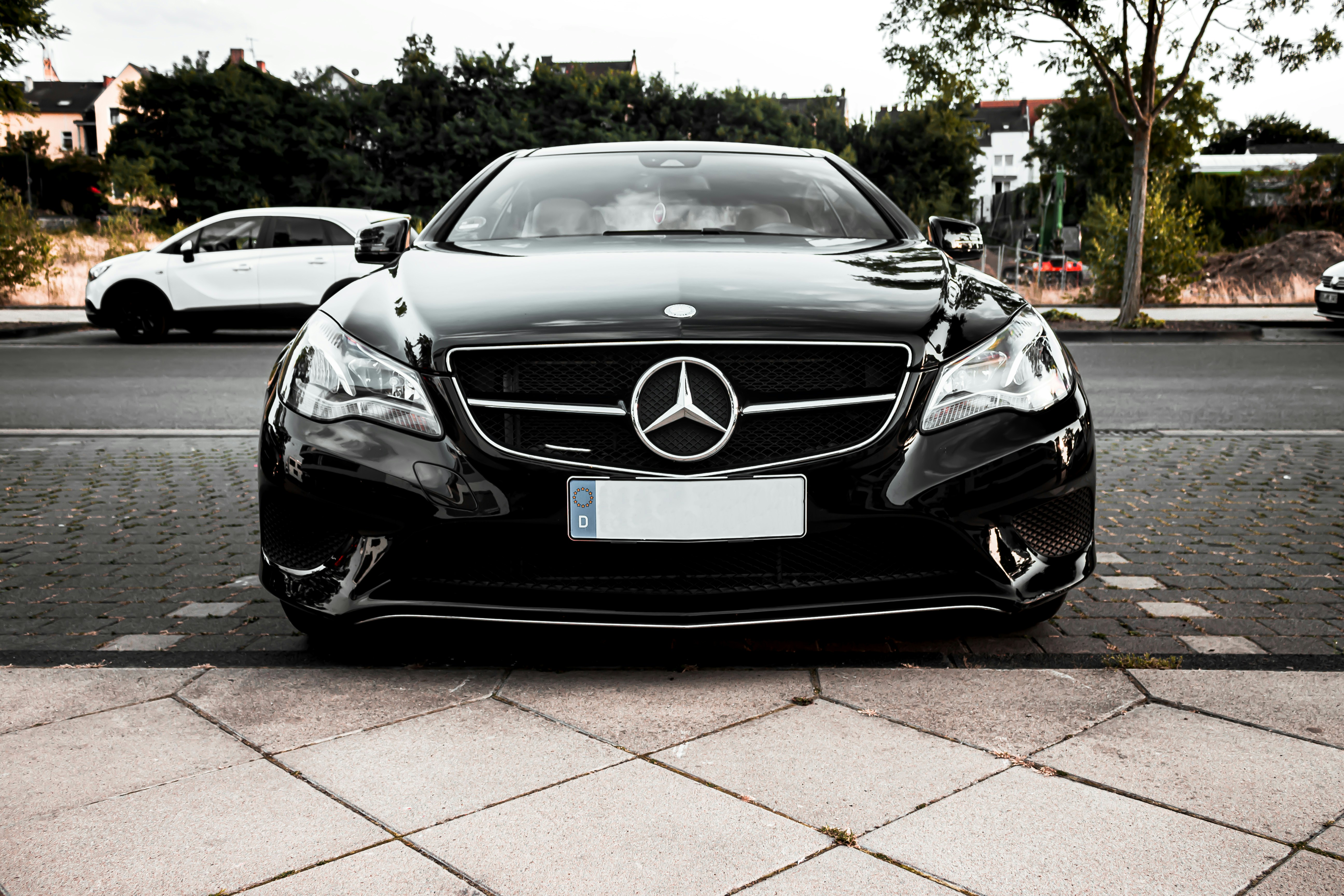 black Mercedes-Benz vehicle parked along side the road