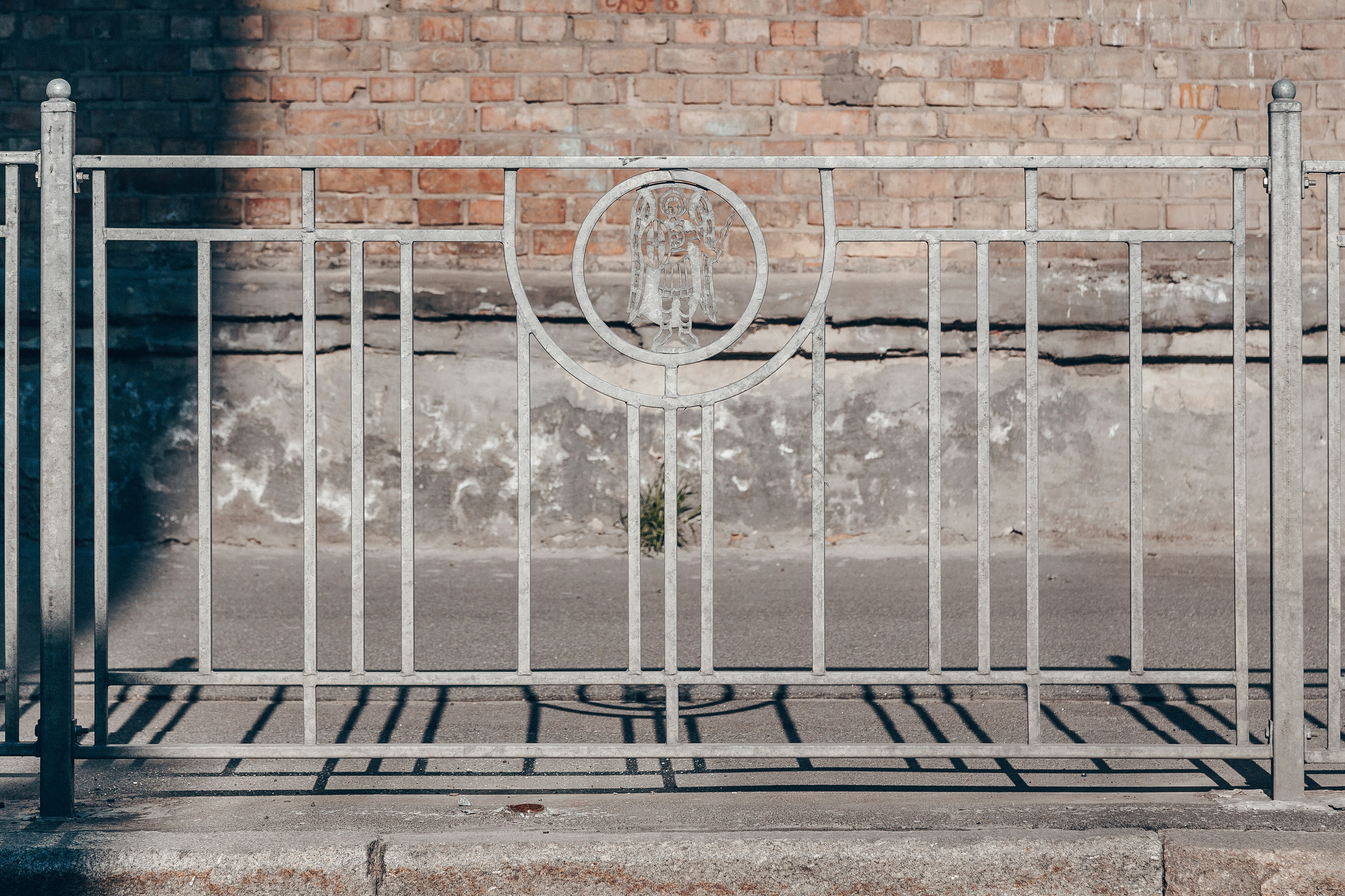 white metal fence near wall