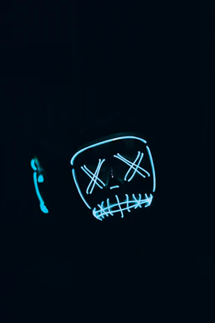 A sleek black mug featuring a glowing demon mask design with neon green accents.