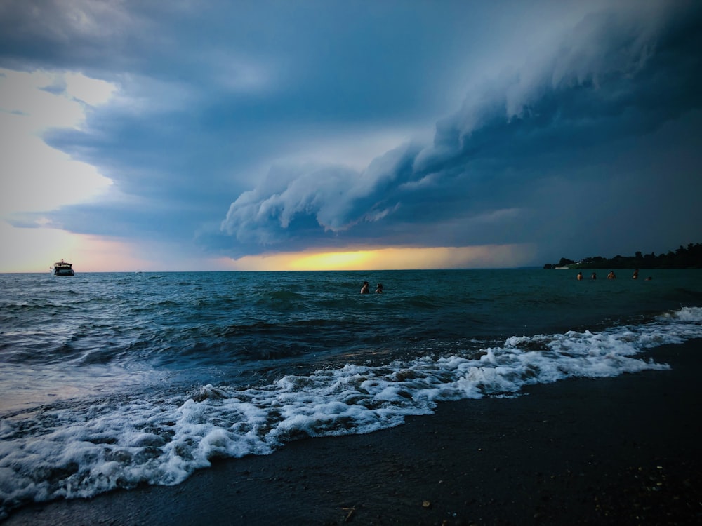 man and woman in sea under clouded sky